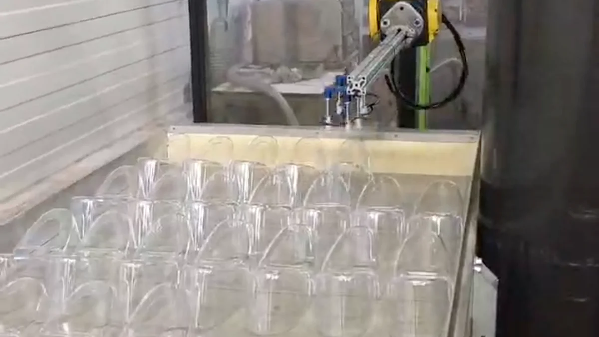 Clear molded parts beside an automated injection molding cell