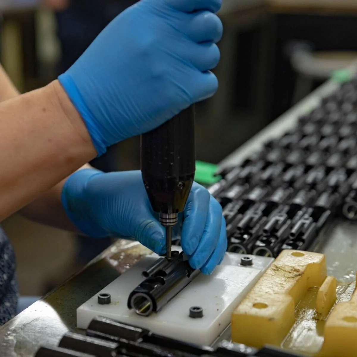 Operator assembling molded plastic components at a work fixture
